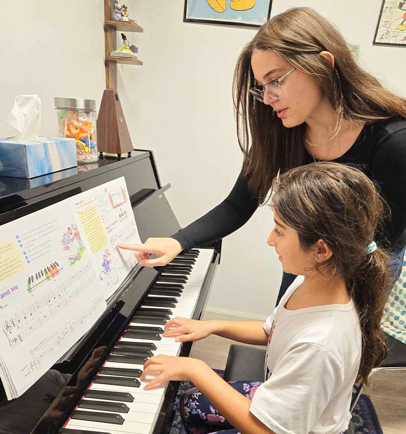 teacher with student on piano